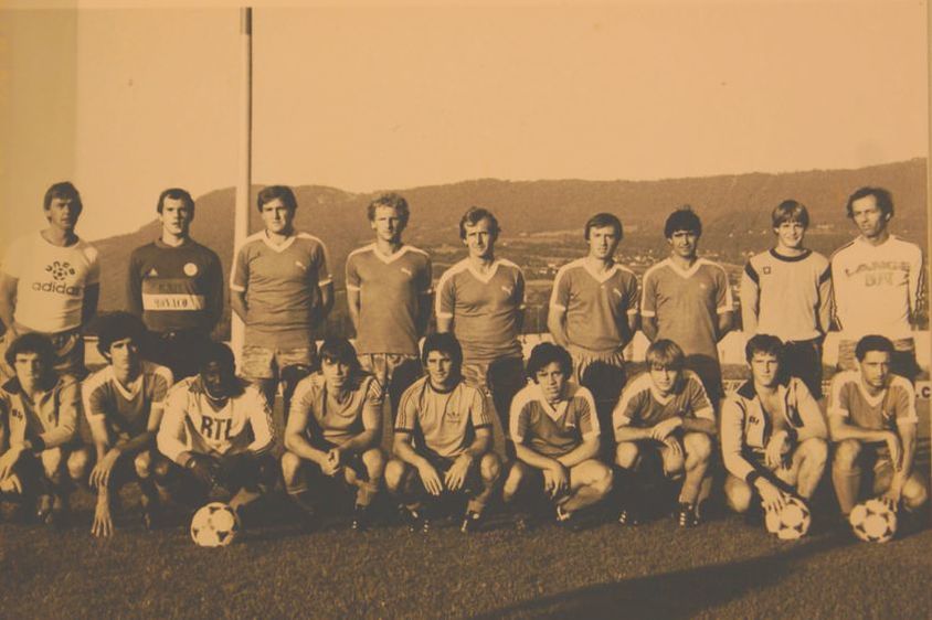 A yellowed photo of a soccer team, with some hills in the background